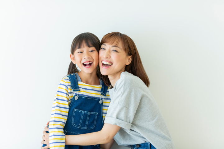 笑顔で頬を寄せる親子