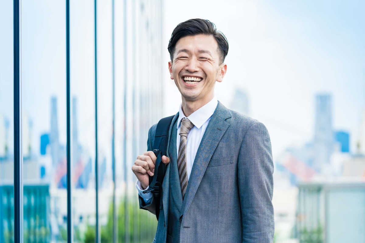 親知らずを抜いて良くなった口内環境に満足して笑う会社員
