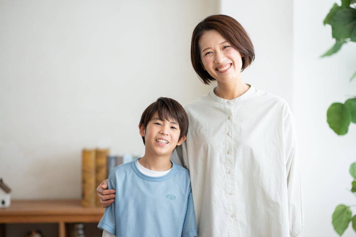 床矯正で綺麗な歯並びいなった男の子と笑顔の母親