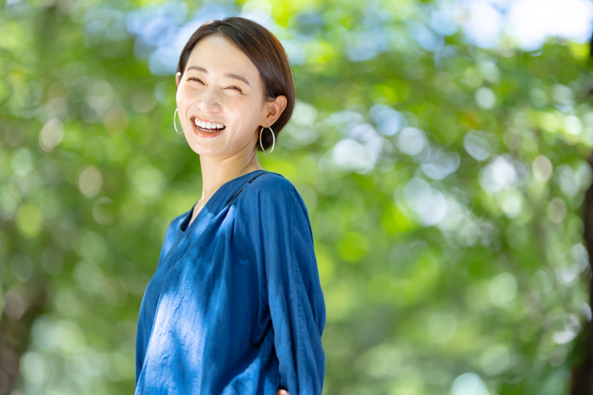 緑の下で笑顔いっぱいの女性